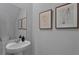 A powder room featuring a pedestal sink, framed artwork, and neutral wall color at 3310 Wye Oak Dr, Apopka, FL 32703