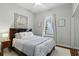 Well-lit bedroom featuring a picture window, hardwood floors, ceiling fan and nautical wall art at 387 Devon Pl, Lake Mary, FL 32746