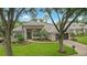 Inviting single-Gathering home featuring a tile roof, lush landscaping, and an attached two car garage at 387 Devon Pl, Lake Mary, FL 32746