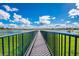 Scenic lake view from a bridge with vibrant green grass, a metal railing, and houses across the water at 387 Devon Pl, Lake Mary, FL 32746