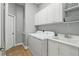 Well-lit laundry room featuring cabinets, utility sink, tile floors, washer and dryer at 387 Devon Pl, Lake Mary, FL 32746