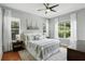 Bright main bedroom with large windows, ceiling fan, hardwood floors and decorative pillows at 387 Devon Pl, Lake Mary, FL 32746
