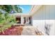 Inviting front entrance with a glass paneled door, surrounded by mulch landscaping and vibrant green plants at 42 W Grenewood Ln, Haines City, FL 33844