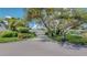 Charming single-story home with lush landscaping, mature trees, and a long driveway leading to an attached two-car garage at 42 W Grenewood Ln, Haines City, FL 33844