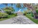 Charming home featuring a well-manicured lawn, lush landscaping, and a long driveway leading to a two-car garage at 42 W Grenewood Ln, Haines City, FL 33844
