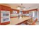 Charming kitchen with wood cabinetry, a center island with bar stools, and stainless steel appliances for a modern touch at 42 W Grenewood Ln, Haines City, FL 33844