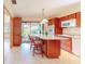 Warm kitchen with wood cabinets, an island with seating, and a large window overlooking the lush backyard at 42 W Grenewood Ln, Haines City, FL 33844