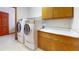 A laundry room featuring a washer and dryer, oak cabinets, and a countertop at 42 W Grenewood Ln, Haines City, FL 33844