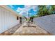 A backyard patio with a closed umbrella, outdoor seating, and a concrete privacy wall at 42 W Grenewood Ln, Haines City, FL 33844