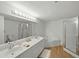 Well-lit bathroom featuring double sinks, a large mirror, a tub, and a separate glass-enclosed shower at 426 Bouchelle Dr # 202, New Smyrna Beach, FL 32169