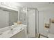 All-white bathroom features glass enclosed shower, vanity with sink, and tile floors at 426 Bouchelle Dr # 202, New Smyrna Beach, FL 32169