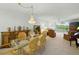 Elegant dining room featuring a chandelier, glass-top table, and a view of the living area at 426 Bouchelle Dr # 202, New Smyrna Beach, FL 32169