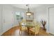Bright dining area featuring a glass table, decorative chandelier, and wood-look floors at 426 Bouchelle Dr # 202, New Smyrna Beach, FL 32169