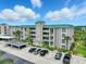 Multi-story condo building with green roof, tropical landscaping, and ample parking at 426 Bouchelle Dr # 202, New Smyrna Beach, FL 32169