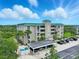 Multi-story condo building with green roof, tropical landscaping, and ample parking at 426 Bouchelle Dr # 202, New Smyrna Beach, FL 32169