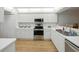 Well-lit kitchen with stainless steel appliances, white cabinets, and laminate floors at 426 Bouchelle Dr # 202, New Smyrna Beach, FL 32169