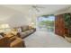 Inviting living room features a comfortable sofa, ceiling fan, and a large window overlooking greenery at 426 Bouchelle Dr # 202, New Smyrna Beach, FL 32169