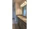 Bathroom vanity featuring double sinks, granite counters, gray cabinets, and tile flooring at 483 Shadow Gorge Way, Eustis, FL 32736