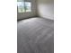 Bright bedroom featuring a large window providing natural light, and plush gray carpeting at 483 Shadow Gorge Way, Eustis, FL 32736