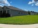 Side view of house with a pristine lawn surrounded by lush greenery at 483 Shadow Gorge Way, Eustis, FL 32736