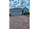 Charming single-story home featuring a paved driveway and attached two-car garage at 483 Shadow Gorge Way, Eustis, FL 32736