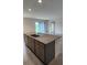 Kitchen island with granite counters, cabinets, stainless steel sink, and dining area at 483 Shadow Gorge Way, Eustis, FL 32736