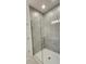 Modern bathroom shower featuring gray tiled walls, glass door, and white shower pan at 483 Shadow Gorge Way, Eustis, FL 32736