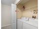 Functional laundry room with a washer, dryer, and storage space on a wire shelf at 4895 Clock Tower Dr, Kissimmee, FL 34746