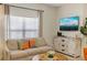 Inviting living room featuring a cozy sofa, rustic wooden cabinet, and modern television for entertainment at 4895 Clock Tower Dr, Kissimmee, FL 34746