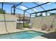 Sparkling swimming pool in a screened-in enclosure with patio furniture for outdoor living at 4895 Clock Tower Dr, Kissimmee, FL 34746