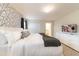 Bright main bedroom with geometrically designed accent wall, closet, and mounted television at 5025 Windermere Ave, Kissimmee, FL 34746