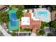 Overhead view of tennis court, pool, clubhouse, and parking with lush landscaping and pond at 5160 Conroy Rd # 21, Orlando, FL 32811