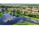 Scenic aerial view of community homes by a pond, nestled among green trees with blue sky reflections at 5160 Conroy Rd # 21, Orlando, FL 32811