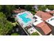 Aerial view of a community pool with lounge chairs, clubhouse and green landscaping at 5160 Conroy Rd # 21, Orlando, FL 32811