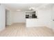 Open living room with white walls and light flooring leading into an open kitchen and stainless steel appliances at 5160 Conroy Rd # 21, Orlando, FL 32811