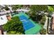 Aerial view of a vibrant blue and green community tennis court surrounded by trees at 5160 Conroy Rd # 21, Orlando, FL 32811