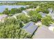 Aerial view of a single-Gathering home showcasing solar panels and lush landscaping near a serene lake at 5263 Beach River Road, Windermere, FL 34786