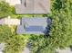 Aerial view of home with solar panels surrounded by lush landscaping and trees at 5263 Beach River Road, Windermere, FL 34786