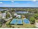 Aerial view of community amenities, including tennis courts, basketball court, pool, and nearby lake at 5263 Beach River Road, Windermere, FL 34786
