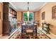 Dining room with a large table and chairs with a view of the tree through the window at 5263 Beach River Road, Windermere, FL 34786