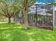 Exterior of a home showing the screened in lanai and beautiful tree covered lawn at 5263 Beach River Road, Windermere, FL 34786