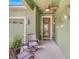 Inviting front porch featuring seating, decorative lighting, and a stylish front door at 5263 Beach River Road, Windermere, FL 34786