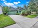 Charming green home featuring a lush landscaped yard, large driveway, and a well-manicured lawn at 5263 Beach River Road, Windermere, FL 34786