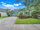 Charming green home featuring a lush landscaped yard, large driveway, and a well-manicured lawn at 5263 Beach River Road, Windermere, FL 34786