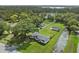 Aerial view of charming home, expansive lawn, outbuilding, and beautiful lake in the background at 5521 Makoma Dr, Orlando, FL 32839