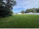 Large backyard with green grass and surrounding mature trees provides privacy and space at 5521 Makoma Dr, Orlando, FL 32839