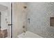 Upgraded bathroom featuring modern tile shower, patterned accent wall, and recessed niche at 5521 Makoma Dr, Orlando, FL 32839