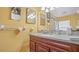 Bathroom featuring a vanity with sink, wood cabinets, mirror, and a walk-in shower at 5891 Sir Henry Rd, Orlando, FL 32808