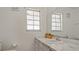 Bathroom featuring a white vanity with a marble countertop and a large mirror at 5891 Sir Henry Rd, Orlando, FL 32808