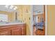 Bathroom featuring a vanity with wood cabinets and a mirror, adjacent to the bedroom at 5891 Sir Henry Rd, Orlando, FL 32808